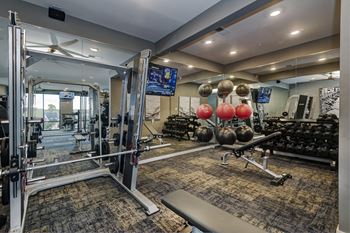 a gym with weights and cardio equipment and a mirror  at Watermark on Twenty Mile, Parker, Colorado